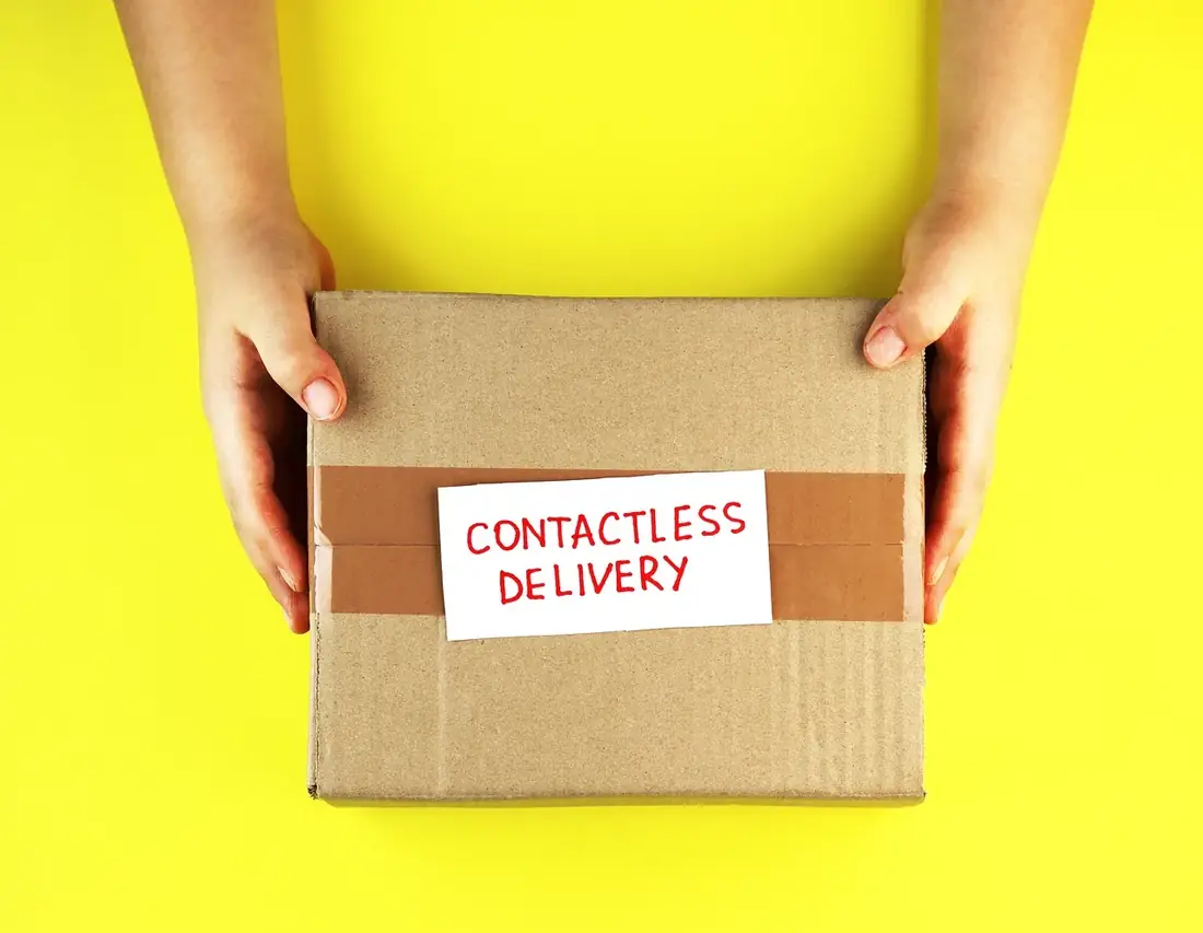 Hands holding a package marked contactless delivery
