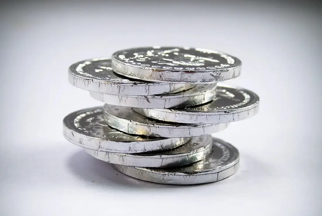 A stack of silver coins on a light background