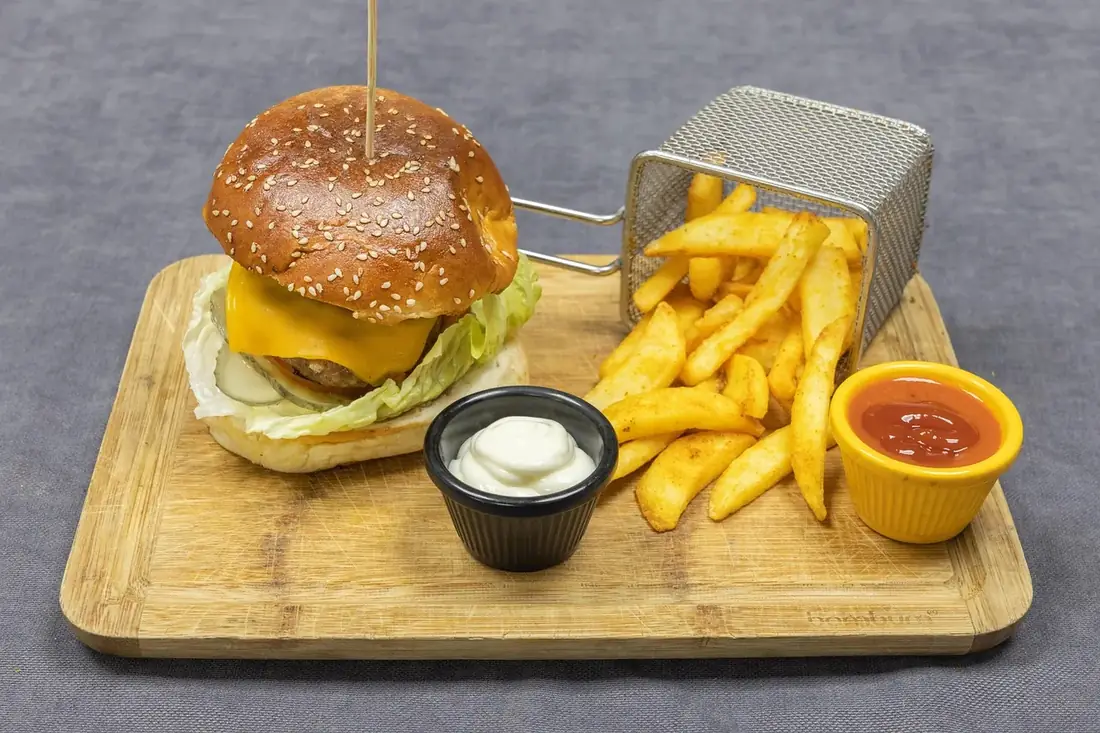 A burger and fries on a wooden board