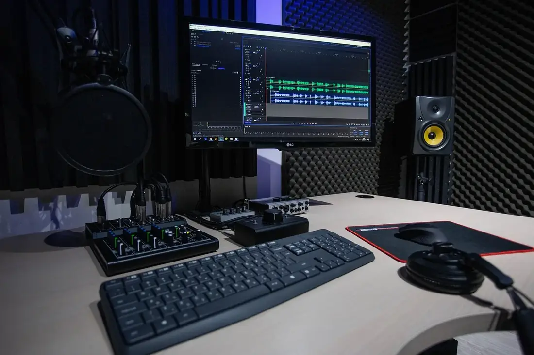 A recording studio desk with a monitor and mixer