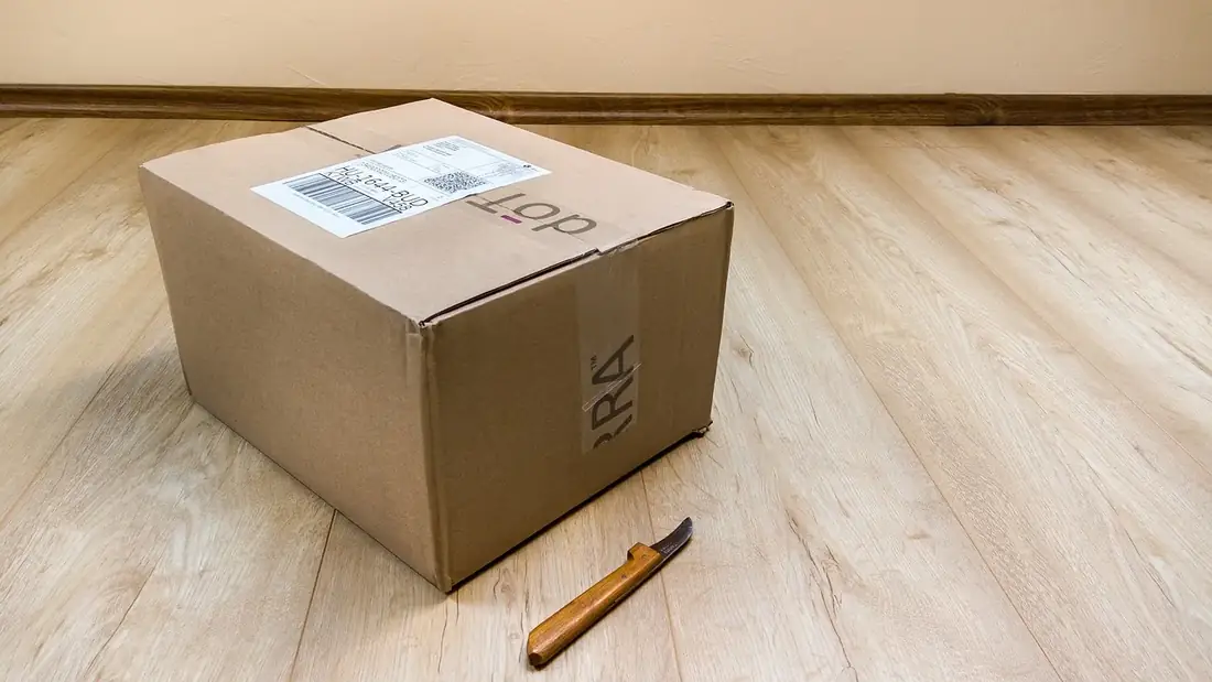A parcel with a shipping label on a wooden floor