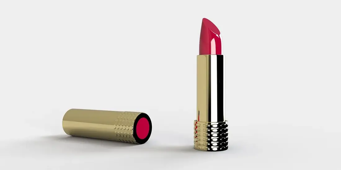 A lipstick standing next to its cap on white