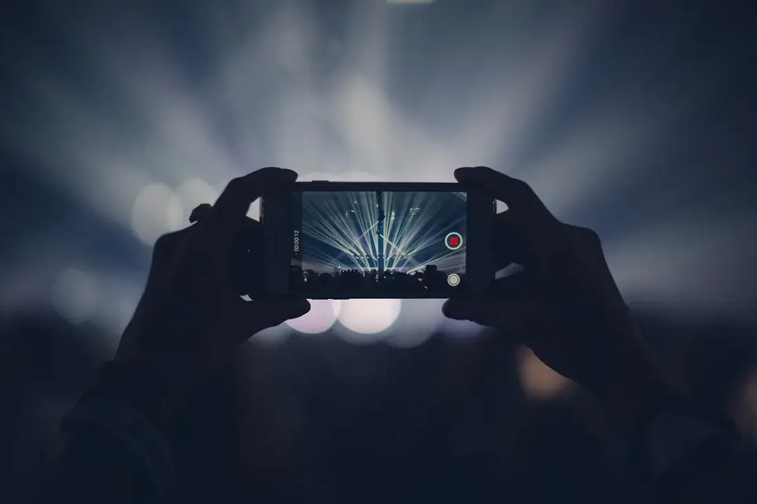 Hands holding a phone to record video