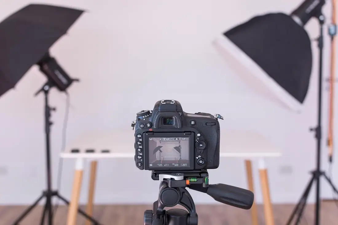 A camera on a tripod in front of studio lights